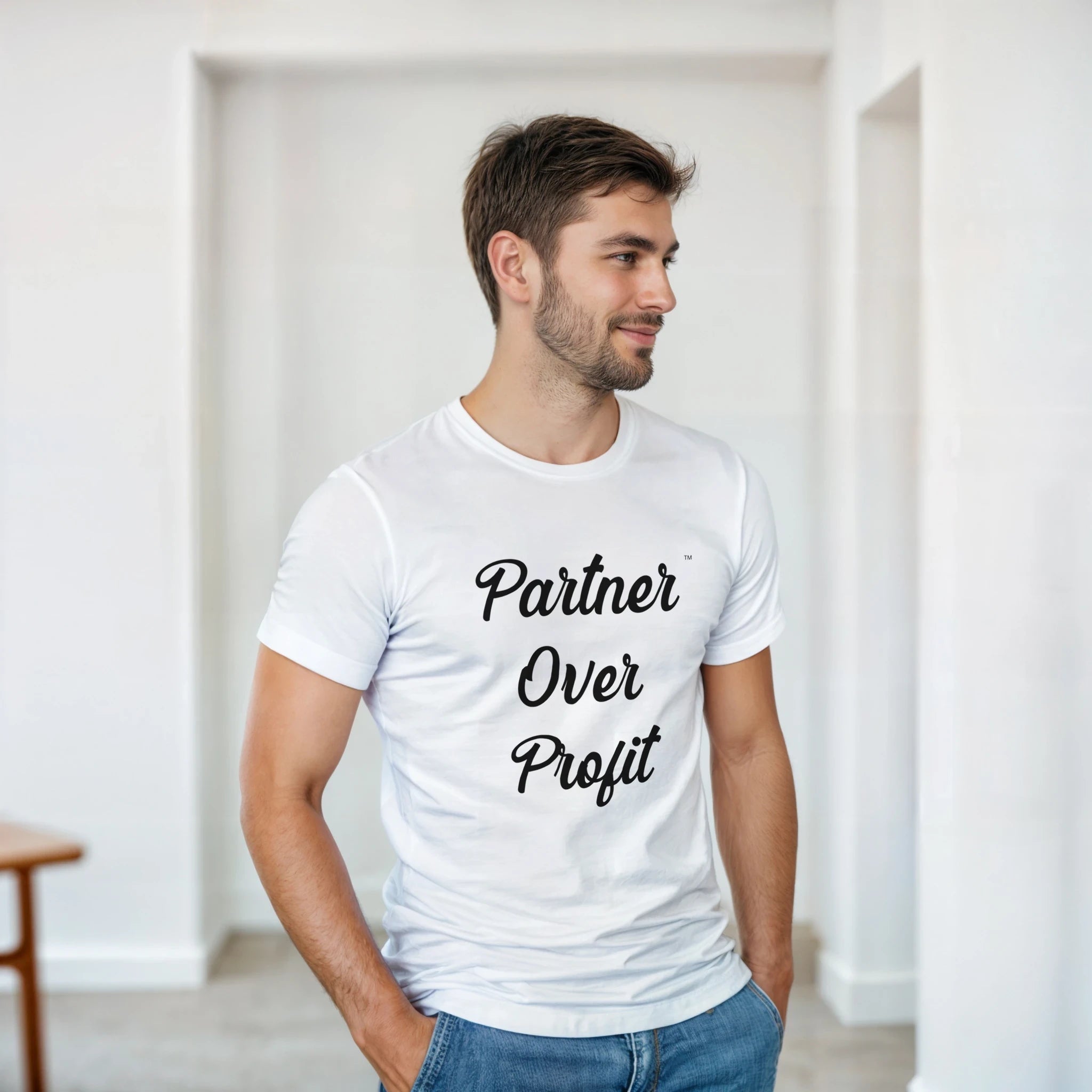 Man wearing a white t-shirt with 'Partner Over Profit' text in a minimal indoor setting