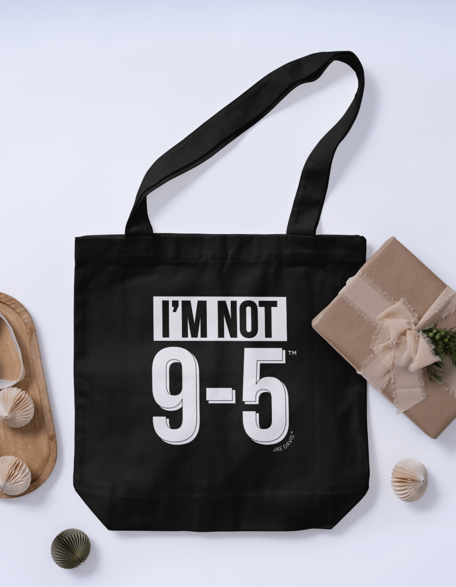 Black tote bag with 'I'm Not 9-5' text on a light gray background