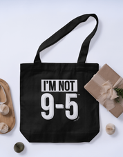 Black tote bag with 'I'm Not 9-5' text on a light gray background