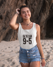 Woman wearing a tank top with 'I'm not 9-5' text on a beach