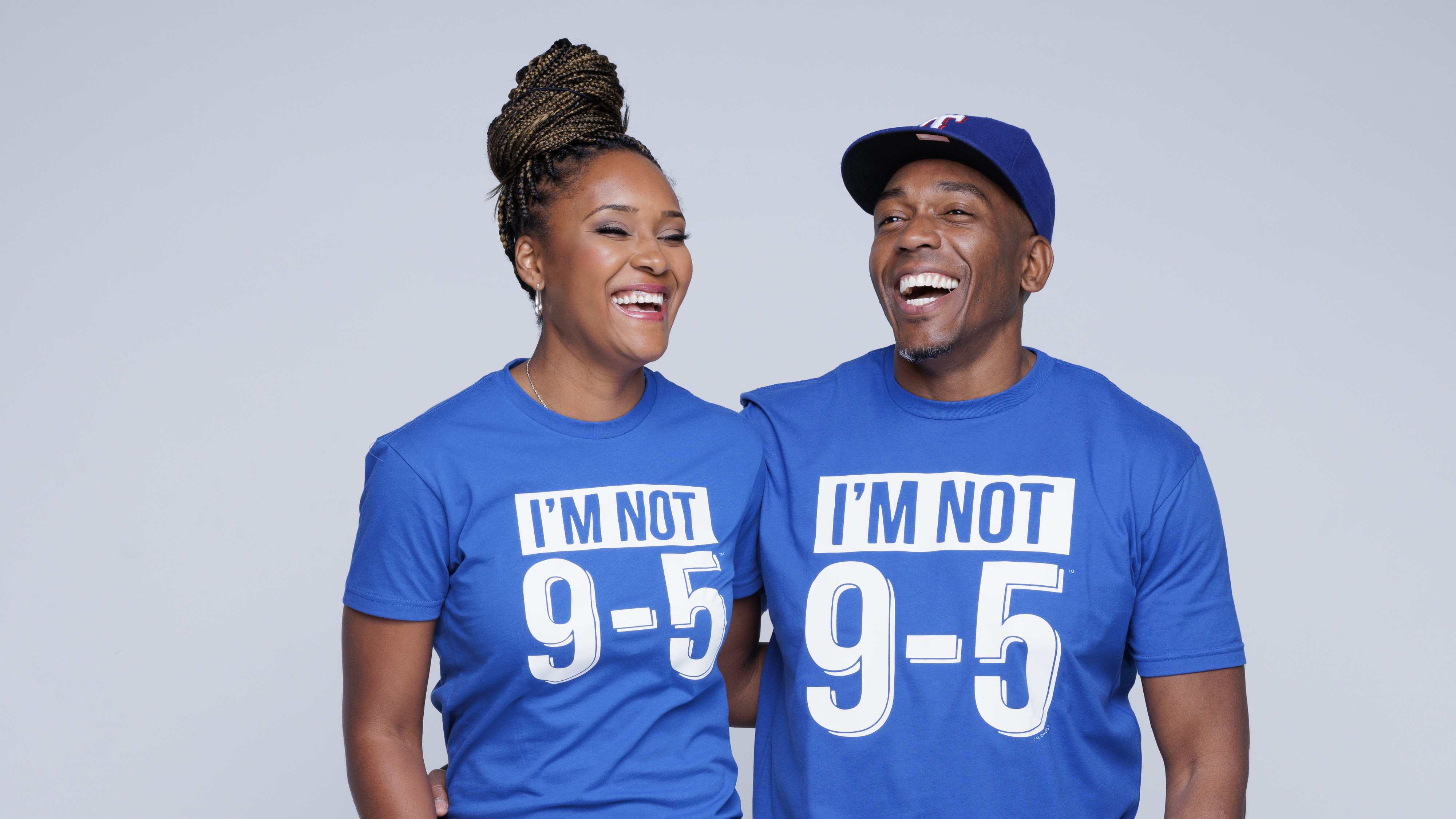 Two people wearing blue t-shirts with 'I'm Not 9-5' text on a gray background