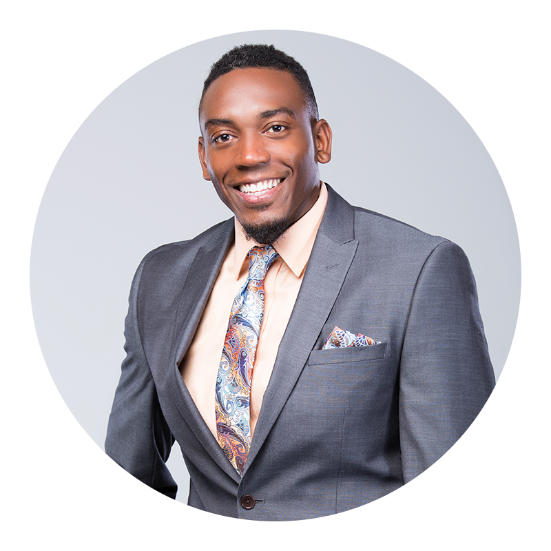 Man wearing a gray suit with a patterned tie and pocket square on a light gray background